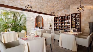 Um restaurante com paredes de tijolo, estantes de madeira e mesas preparadas para refeições.