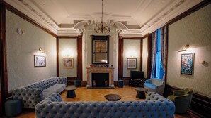 A luxurious lounge area with a fireplace, plush seating, and elegant decor.