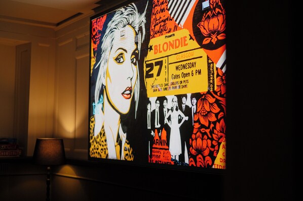 A wall with a large poster featuring a woman and text about an event. - Glasgow Youth Hostel (Glasgow)