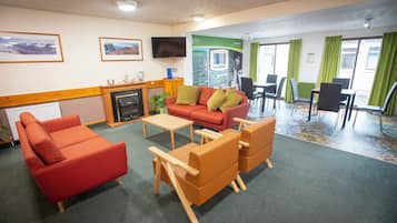 Un espacio de sala amueblado con sofá, sillas, una mesa de centro, chimenea y televisor.