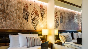Quarto de hotel com cama, um laptop e uma mesa de cabeceira.