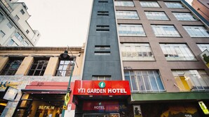 A multi-story hotel with a prominent red sign for YTI Garden Hotel. - YTI Garden Hotel (Melbourne)