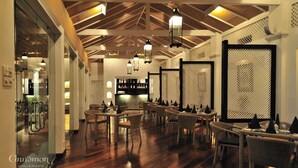 L’intérieur d’un hôtel avec des planchers en bois, des meubles en osier et des lanternes suspendues.