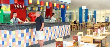 A buffet area with a counter, seating, and a Coca-Cola refrigerator.