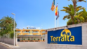An apartment hotel named 'Teralta' with a clear blue sky, palm trees, and a building with balconies. - Terralta (Benidorm)