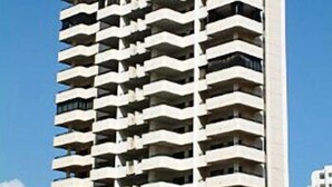 A high-rise building with multiple balconies, likely residential.
