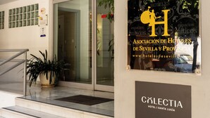 A hotel entrance with a sign for 'H CIUDAD' and 'Asociación de Hoteles de Sevilla y Provincia'. - Colectia Hotel Santa Lucia (Seville)
