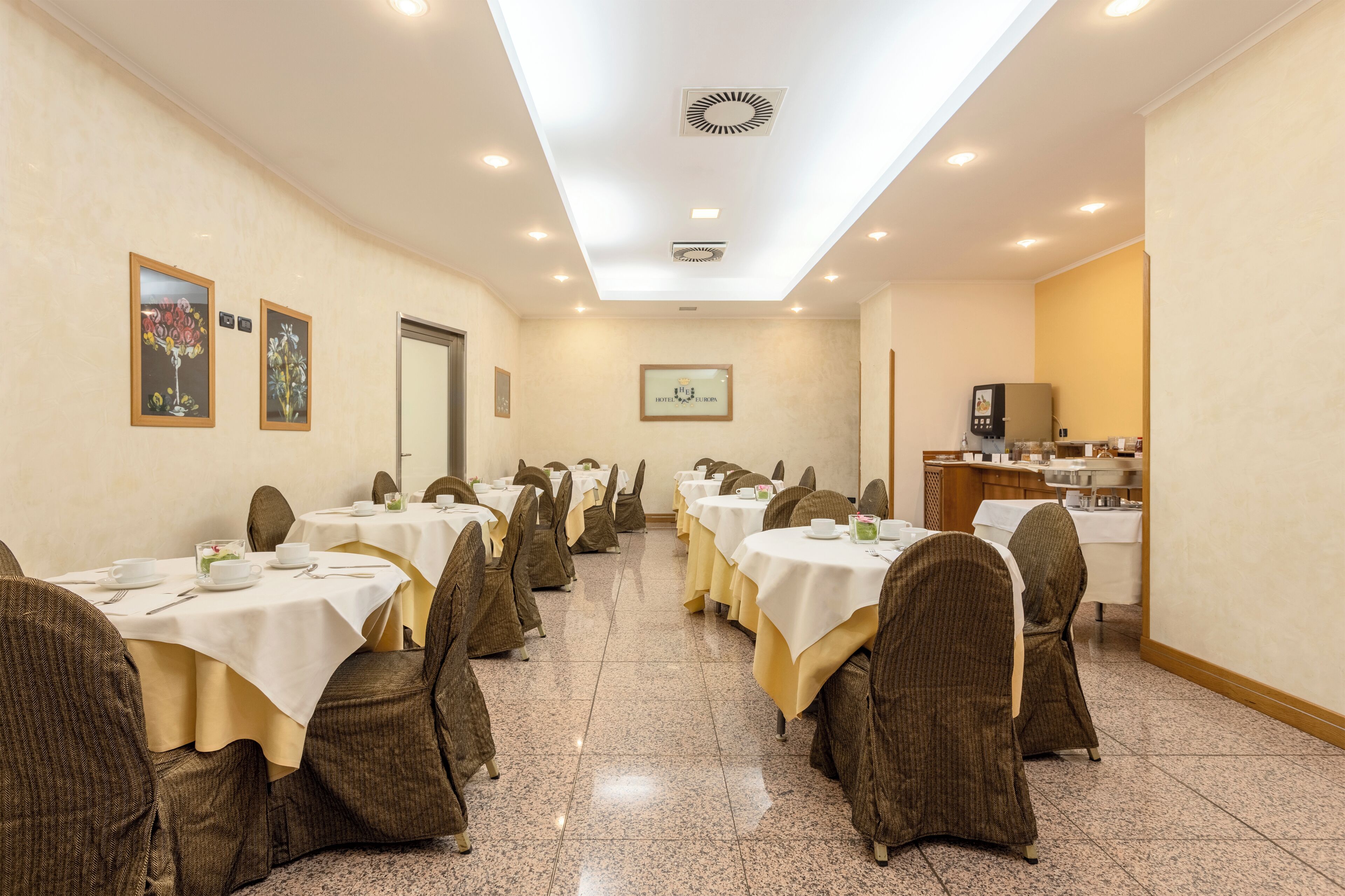 Un salón de conferencias con varias mesas y sillas, equipado con tarjetas de identificación y un atril.