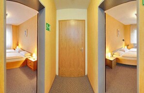 Biancheria da letto ipoallergenica, una scrivania, tende oscuranti