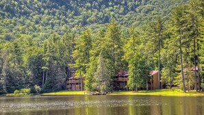 A lakeside lodge with multiple buildings, a dock, and dense forest in the background. - Foxhunt at Sapphire Valley (Sapphire)