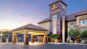 A hotel entrance with a covered waiting area, a prominent tower with the hotel name, and a landscaped driveway. - La Quinta Inn & Suites by Wyndham St. George (St. George)