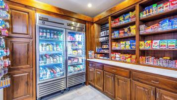 A kitchen with wooden cabinets and a countertop stocked with snacks and beverages.