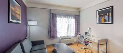 Una habitación moderna con sofá, escritorio y silla.