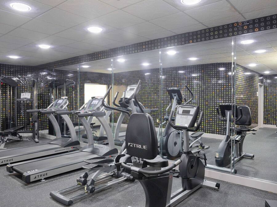 A gym with various exercise equipment, including treadmills and elliptical machines.