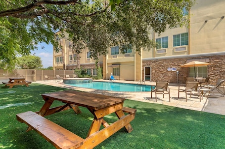 Una piscina al aire libre de temporada, sillones reclinables de piscina