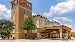 Un hôtel Comfort Inn & Suites doté d’une enseigne bien visible, d’une entrée abritée et d’un espace de stationnement.