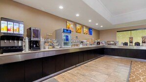 Un bar à petit-déjeuner moderne, doté de distributeurs de boissons en libre-service, d’une machine à café et d’un présentoir réfrigéré.