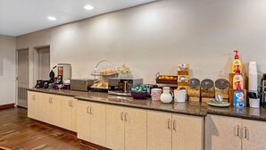 Une cuisine d’hôtel avec un long comptoir, divers produits alimentaires et différents appareils de cuisine.