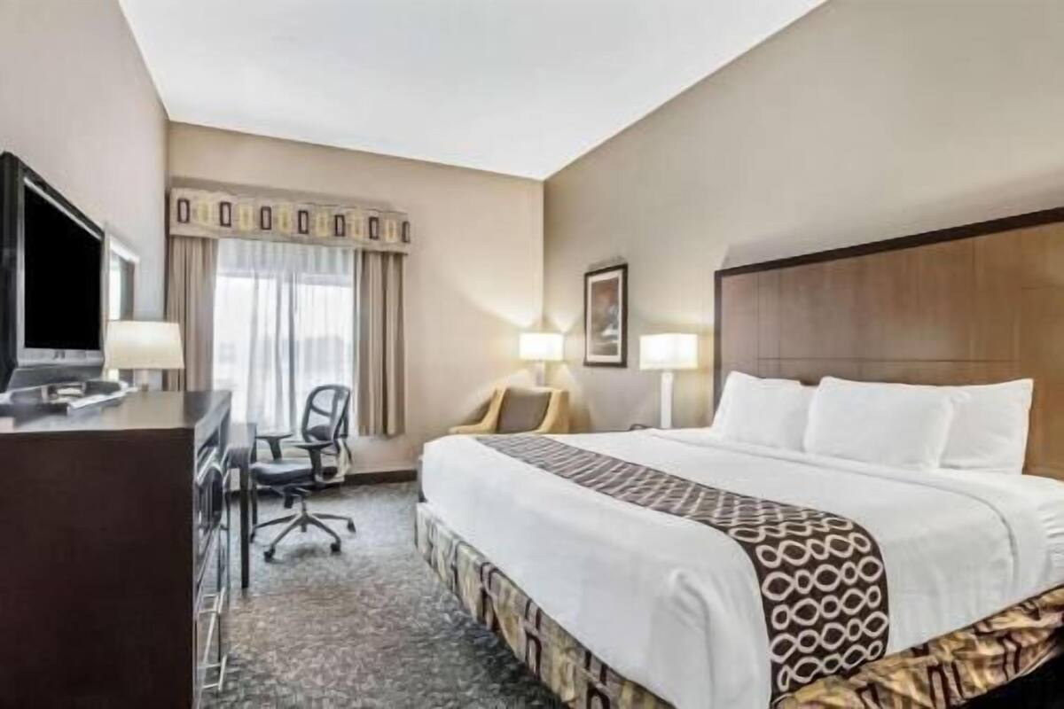 Une chambre d’hôtel équipée d’un lit, d’un bureau, d’une chaise et d’un téléviseur.