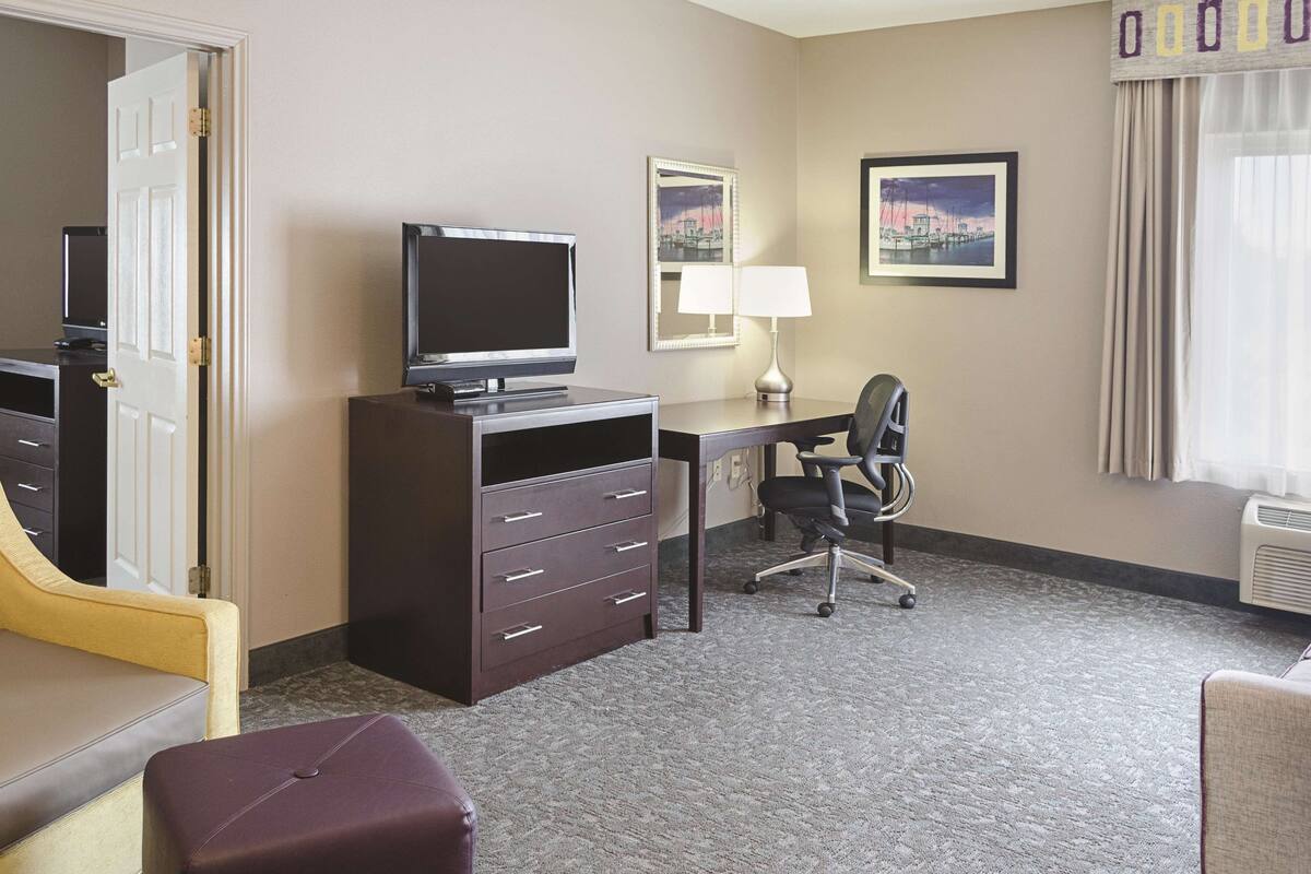 Une chambre d’hôtel équipée d’un bureau, d’une chaise, d’une télévision et d’un lit.