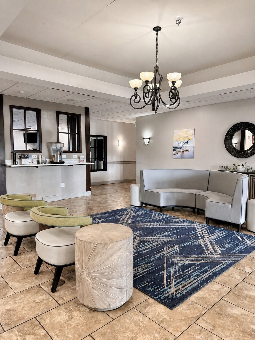Ein modernes Wohnzimmer mit einer Kaffeestation, einer Couch und einem gemusterten Teppich.