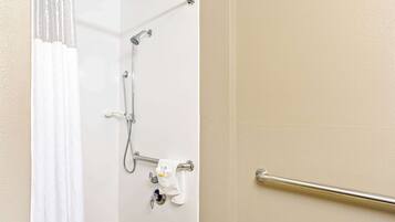 Un bagno con doccia, porta asciugamani e barra di sostegno.
