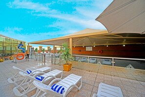 A rooftop terrace with sun loungers, a potted plant, and a lifebuoy. - Emirates Stars Hotel Apartments Dubai (Dubai)