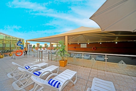 Outdoor pool, pool umbrellas, sun loungers. Emirates Stars Hotel Apartments Dubai