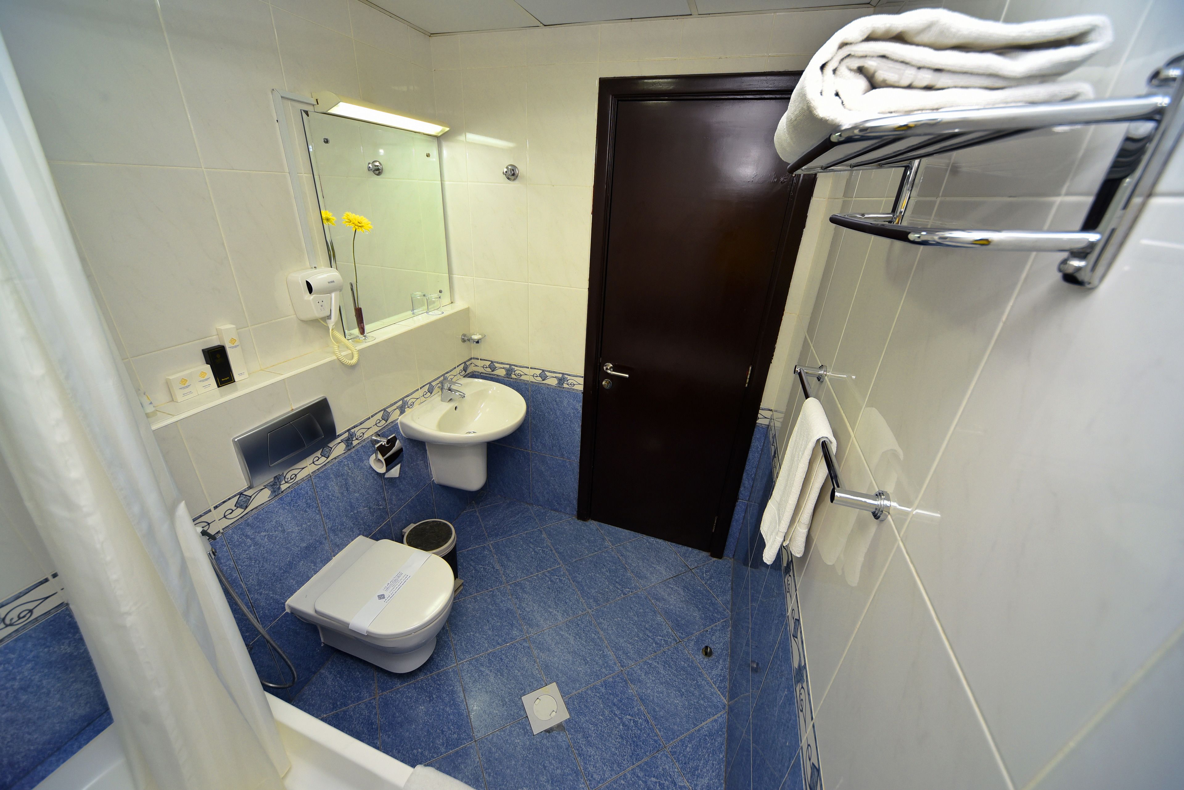 Ein Badezimmer mit Toilette, Bidet, Waschbecken und Handtuchhalter.