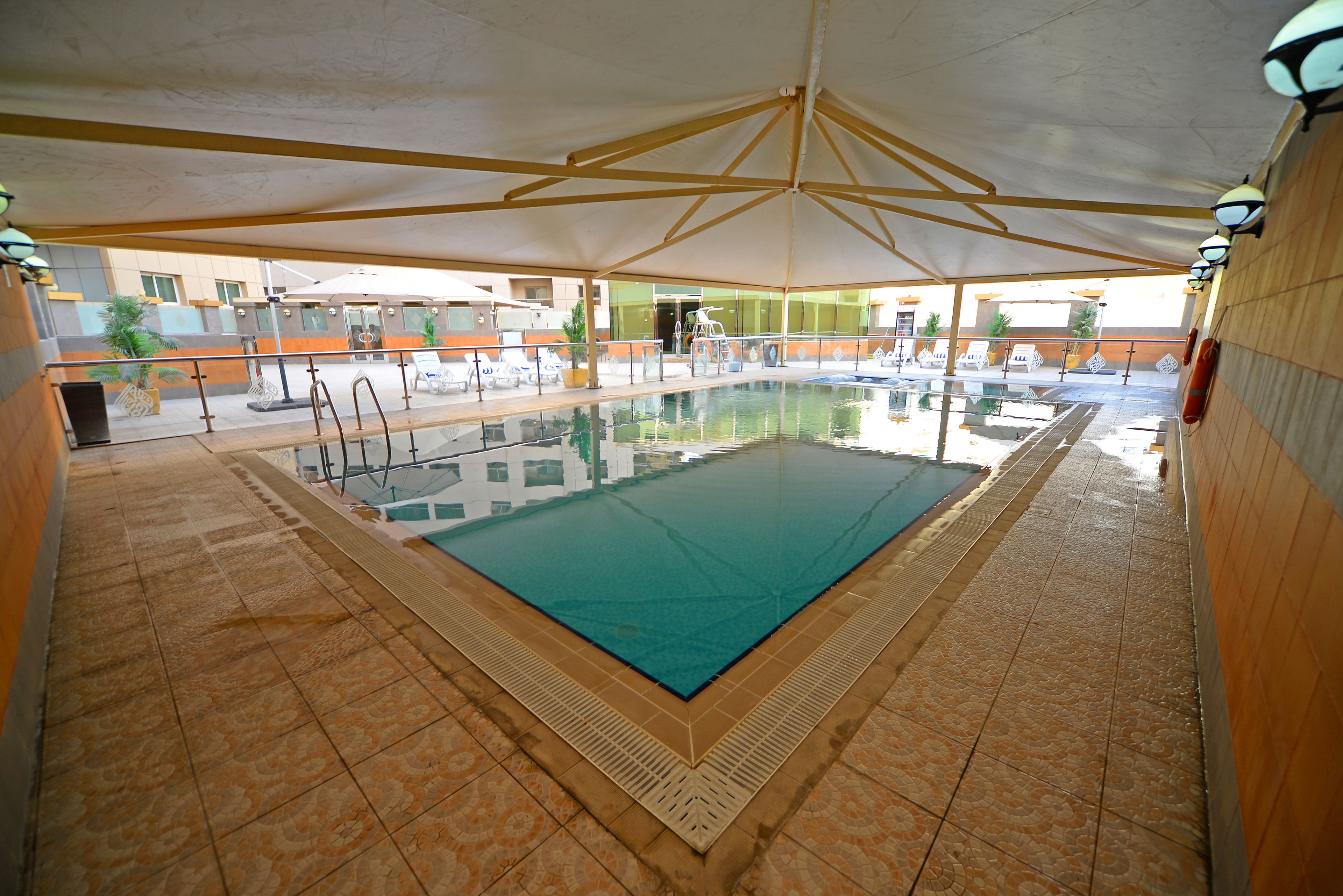 حمّام سباحة خارجي، مظلات على حمّام السباحة، مقاعد للتشمس