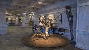 Un vestíbulo amplio con una mesa de madera central que presenta una escultura de árbol única.