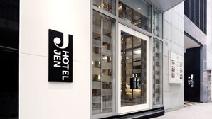 Ein moderner Hotel Eingang mit Glasfassade, einem gut sichtbaren Logo und einem klaren, minimalistischen Design.