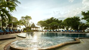 Ein Schwimmbad mit Liegestühlen und einem Pavillon.