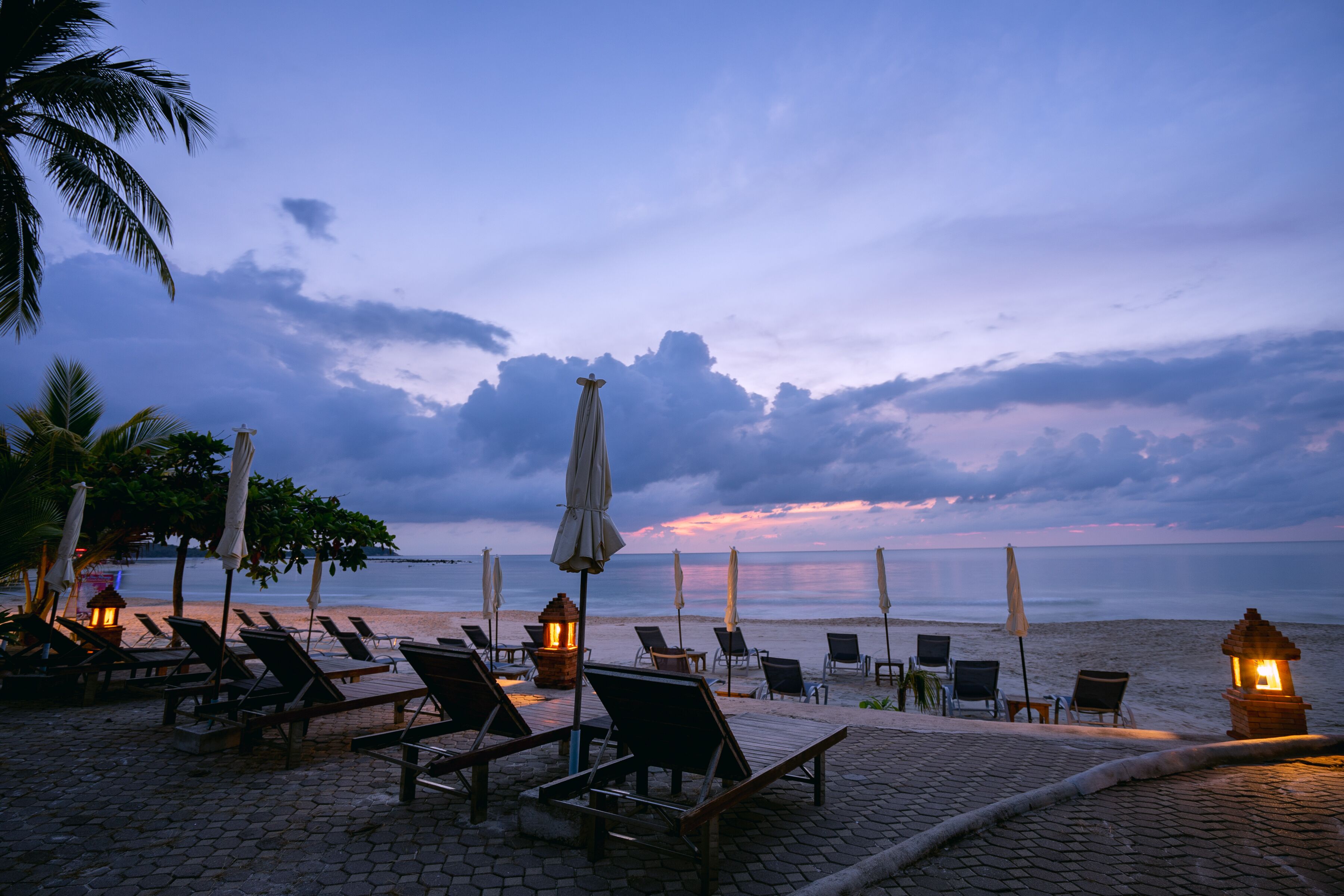 Un salon de plage doté de chaises longues et de parasols, avec vue sur l’océan.