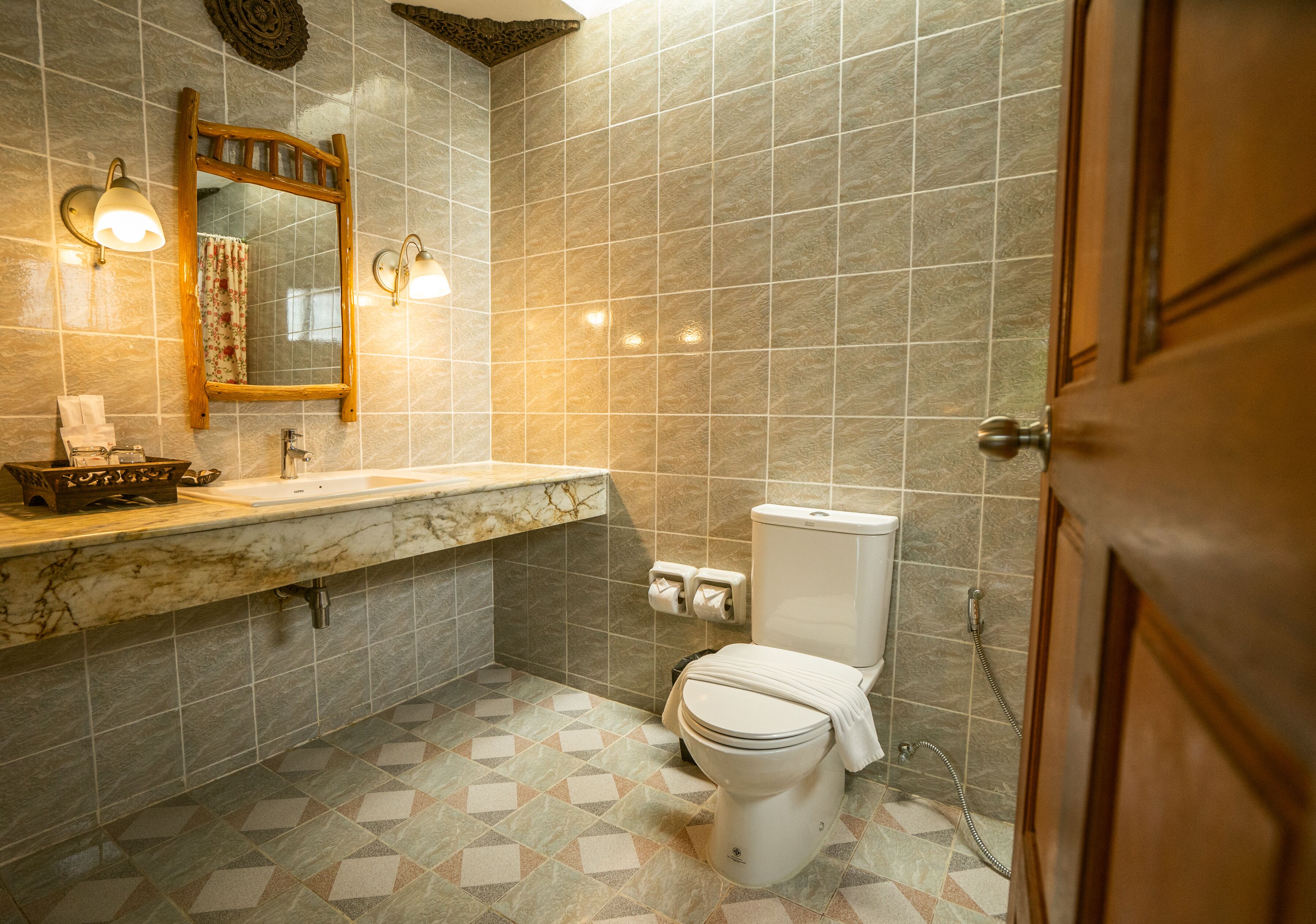 A bathroom with a marble sink, a toilet, and a shower.