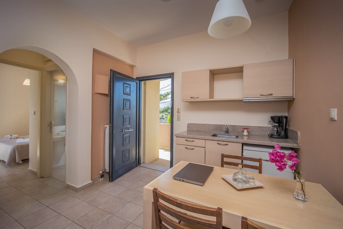 A compact kitchen with a dining area, a small coffee station, and a view of the outside.