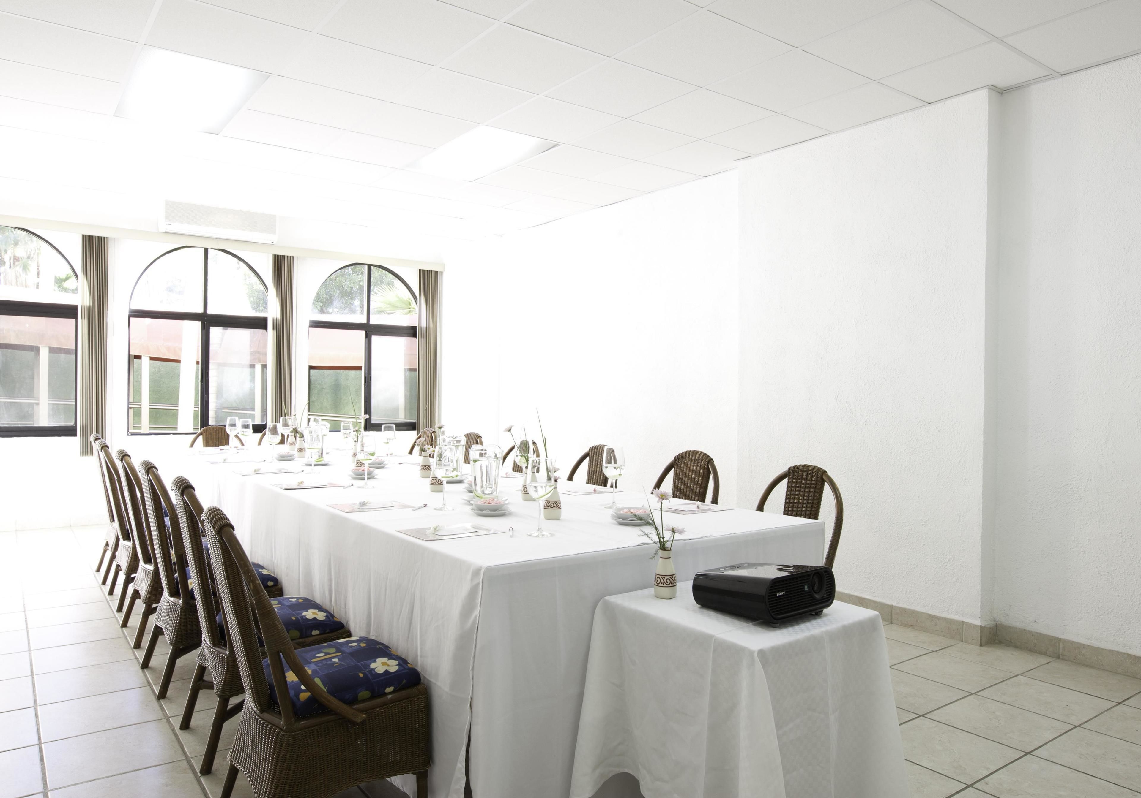 A conference room with a long table, chairs, and a projector.