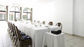 A conference room with a long table, chairs, and a projector.