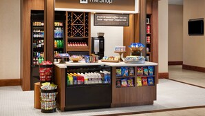 A self-service kiosk in a hotel lobby with a sign reading "The Shop" offering fresh-brewed coffee, hot tea, latte, espresso, and cappuccino. - Hilton Garden Inn Dallas Richardson (Richardson)