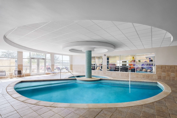 Una piscina techada, sillones reclinables de piscina