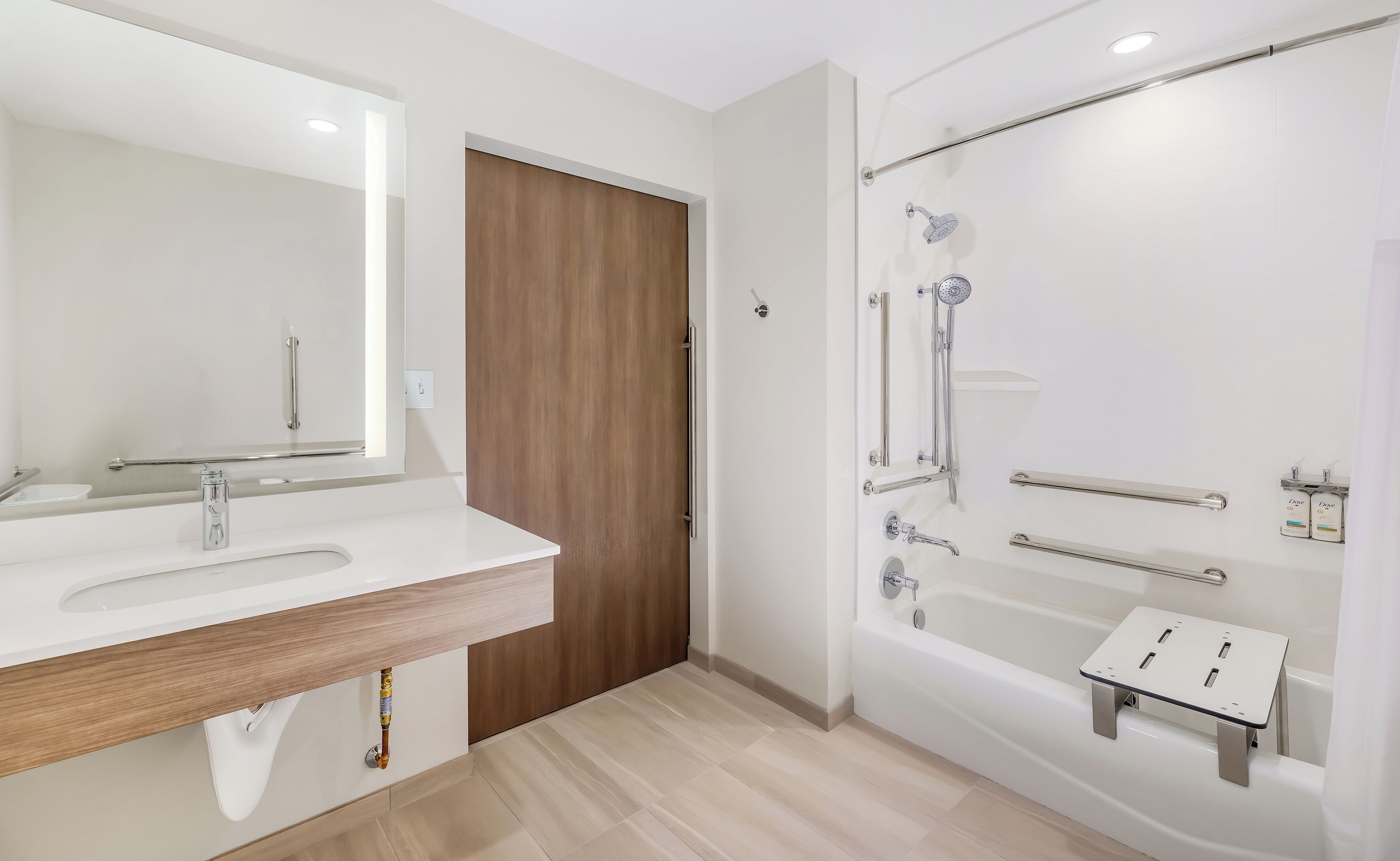 A modern bathroom with a large mirror, a sink, a shower with a handheld showerhead, and a bathtub.