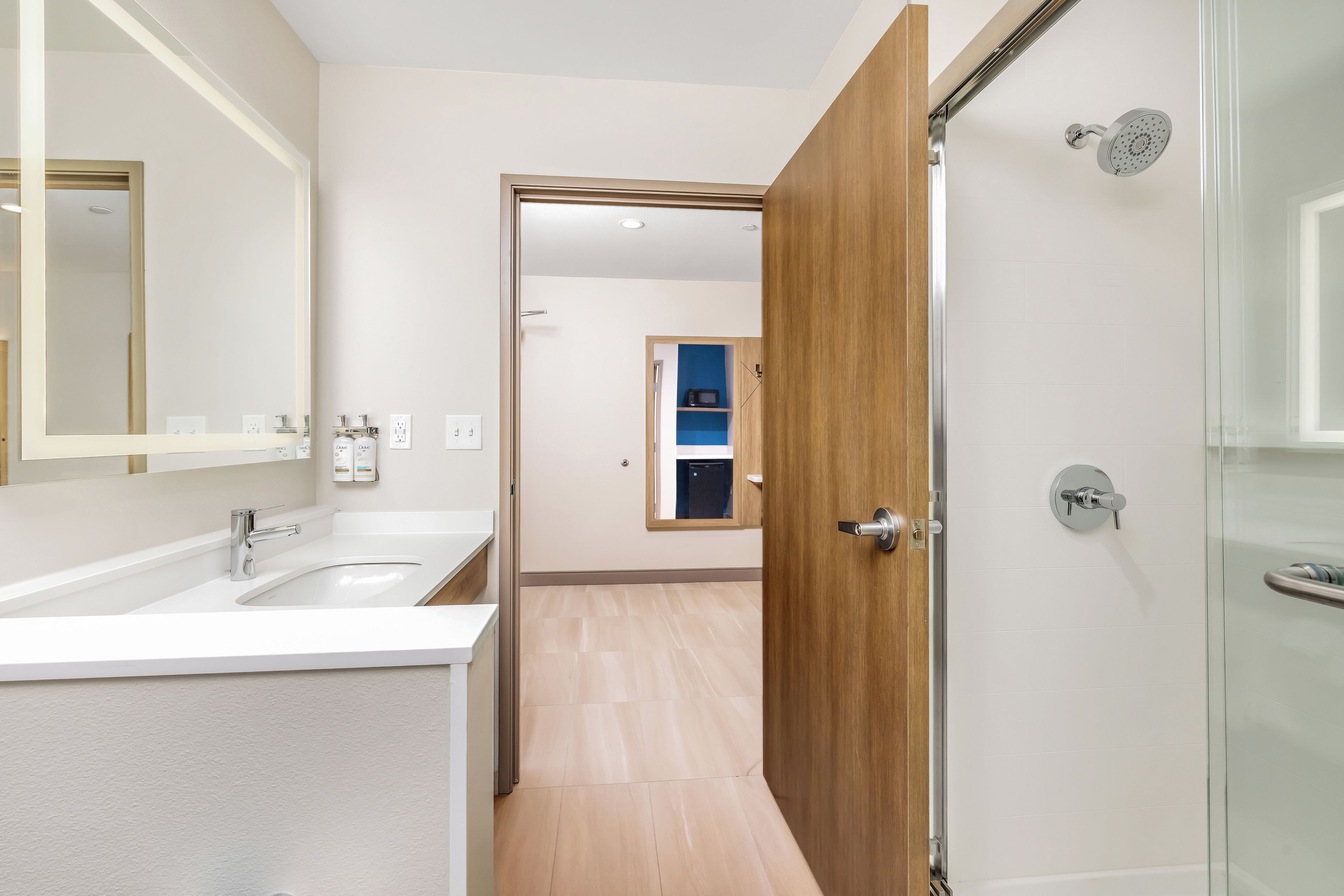 Un baño moderno con ducha, lavamanos y espejo.