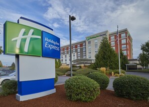 A Holiday Inn Express sign with a modern building in the background. - Holiday Inn Express Eugene - Springfield by IHG (Springfield)