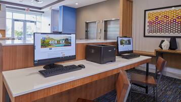 A hotel reception desk with two computer monitors, a keyboard, and a mouse.