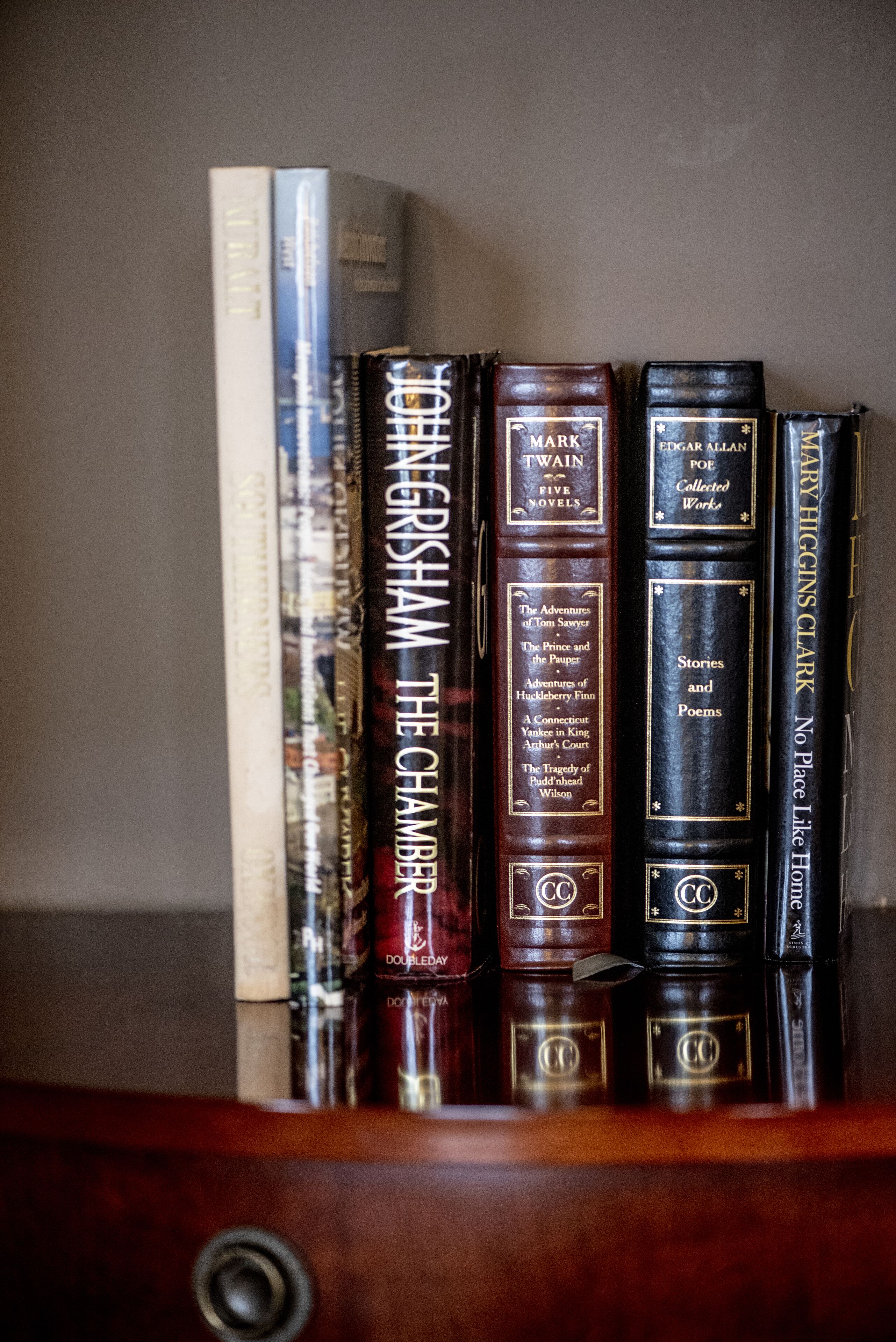 Una colección de libros de tapa dura en un estante.