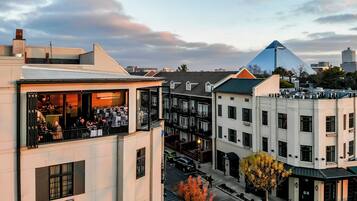 A hotel with a rooftop bar, multiple floors, and a distinctive pyramid-shaped building in the background.