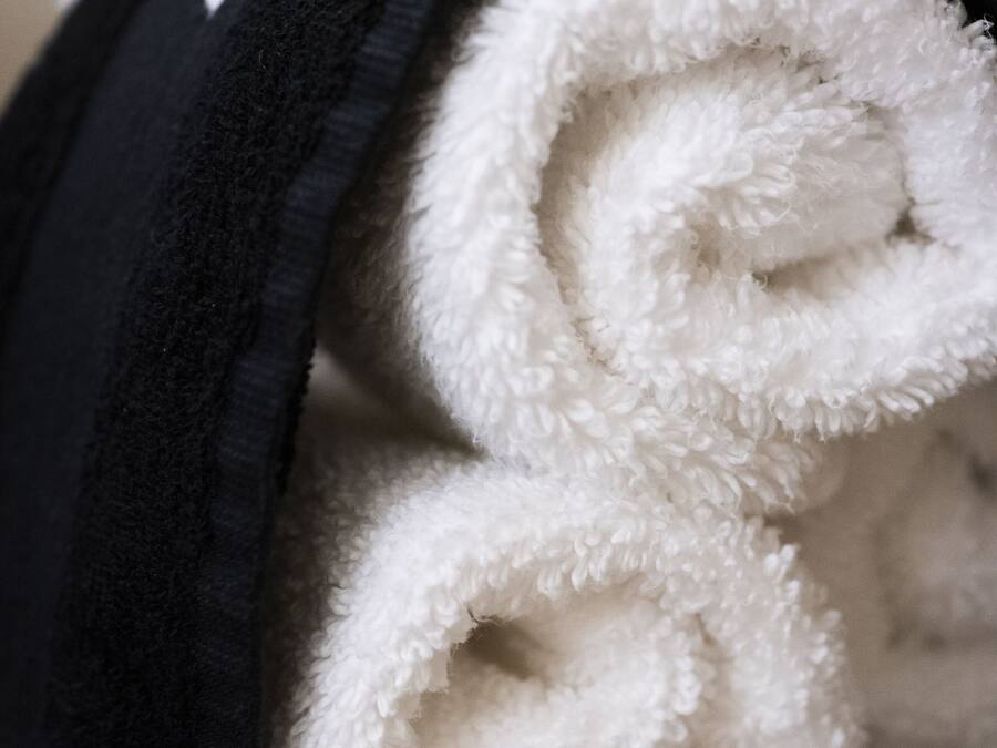 A rolled white towel with a black headband.