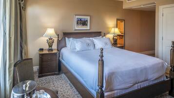 A neatly arranged hotel room with a large bed, two bedside tables with lamps, a chair, and a small table with a tray.
