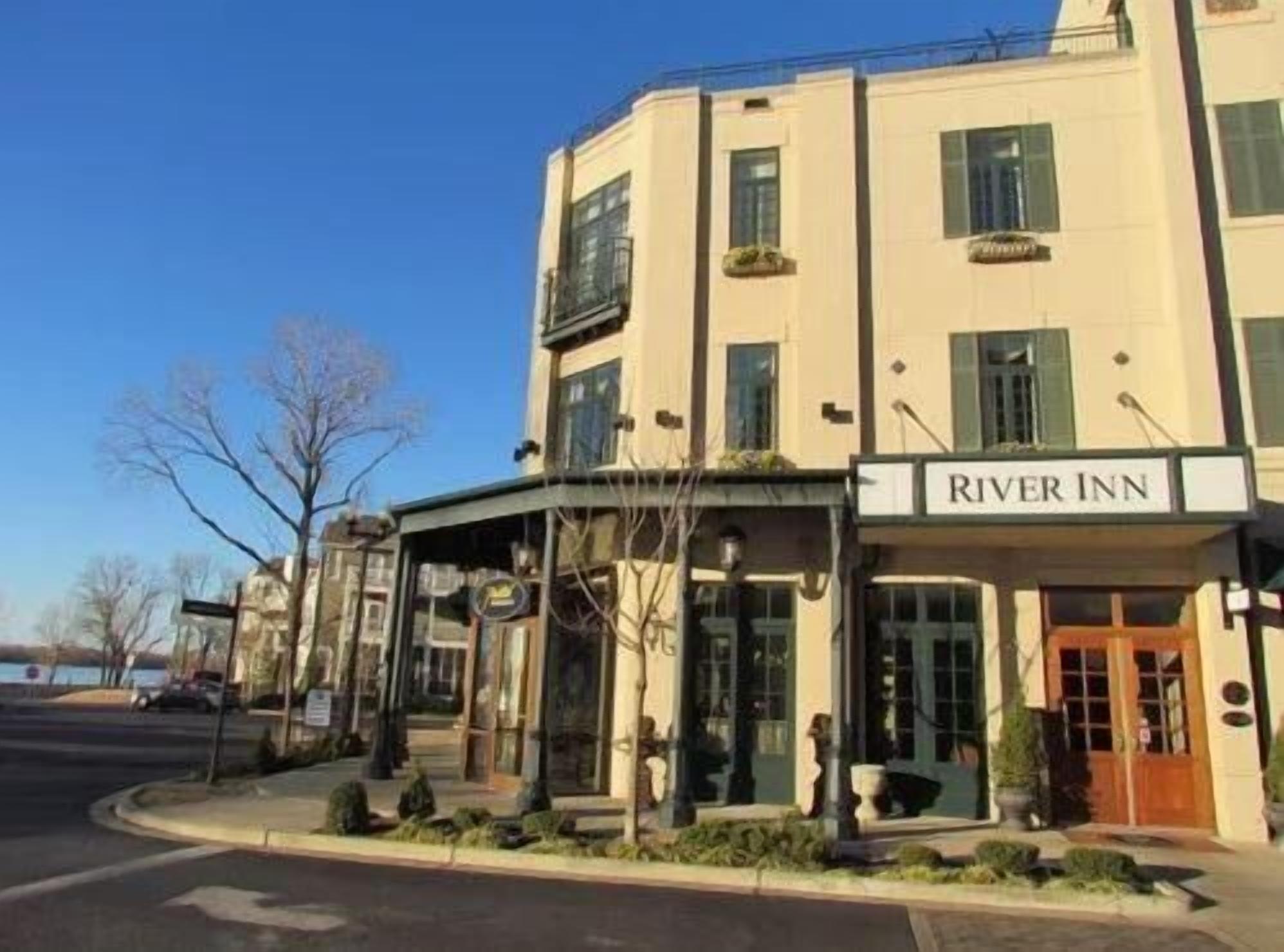 A hotel named River Inn with a classic architectural style, featuring a prominent entrance and a clear view of the surrounding area.