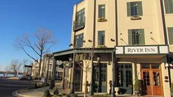 A hotel named River Inn with a classic architectural style, featuring a prominent entrance and a clear view of the surrounding area.